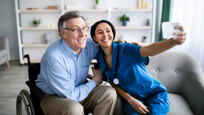 smiling-nurse-taking-selfie-with-senior-patient-in-wheelchair-showing-trust-and-connection